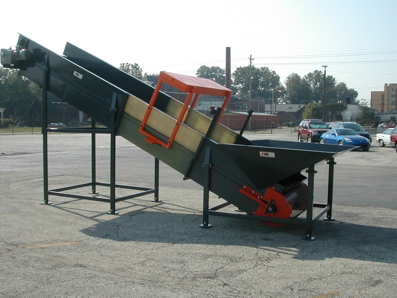 Inclined belt conveyor with feed hopper & metal detector.